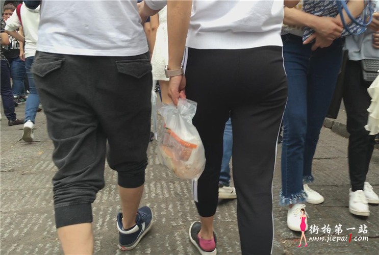 紧身黑色运动裤女孩跟小男友逛街。