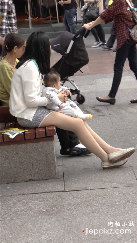 广场边闲坐的丝袜美腿年轻少妇